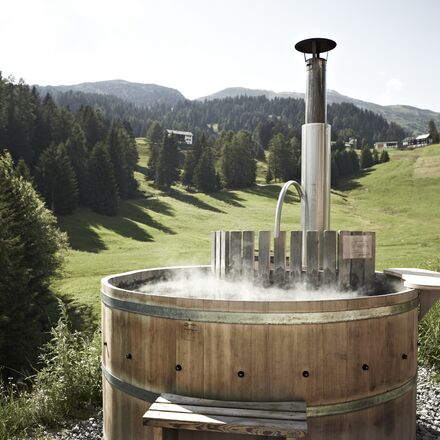 Sonniger Wellnessbereich im Freien mit Liegestühlen und Blick auf die Natur der Quarda Val. | © Guarda Val