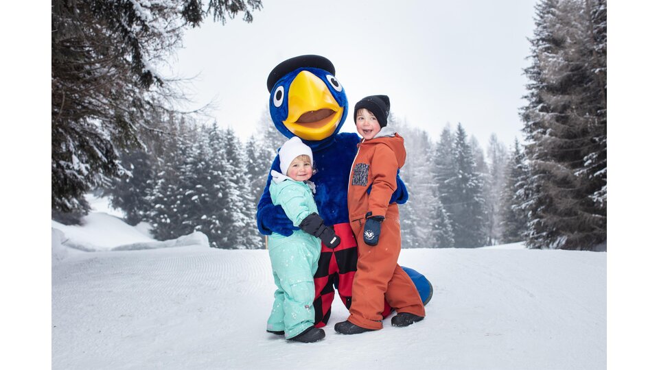 Globi in Lenzerheide im Winter mit zweit Kindern im Schnee. | © Ferienregion Lenzerheide